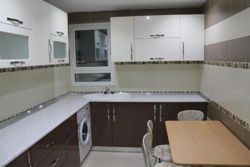 a kitchen with a sink and a table in it at LE JASMIN RESIDENCE in Hammam Sousse