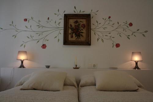 a bedroom with a bed with a flower mural on the wall at Apartamentos La Casa Pintada in Cáceres