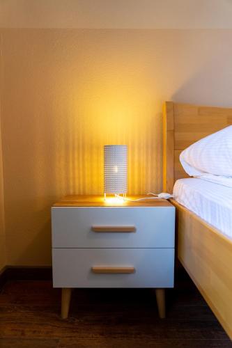 a nightstand with a lamp on it next to a bed at Apartments MoonRiver in Bihać