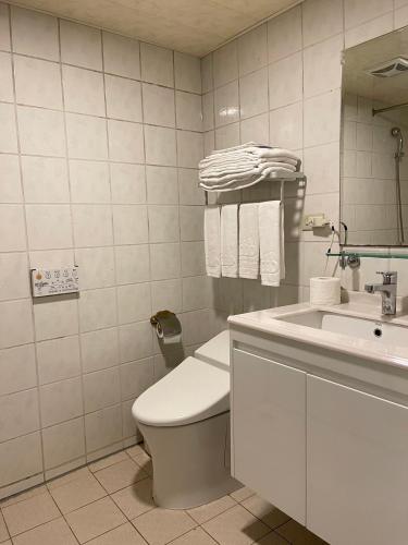 biała łazienka z toaletą i umywalką w obiekcie Dahshin Hotel w Tajpej