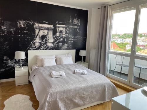 1 dormitorio con 1 cama grande y 2 toallas. en PANORAMIC FAMILY APT with FREE TWO PARKING PLACE AND BREAKFAST, en Budapest