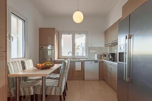 a kitchen with a table with a bowl of fruit on it at Eternal Summer Time Villa for 6 in Dhaskalión