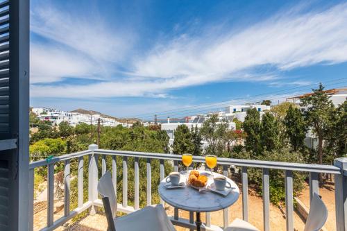 - un balcon avec une table et deux verres de jus d'orange dans l'établissement Hotel Manto, à Náoussa