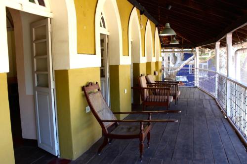 a porch of a building with chairs on it at Royal Phoenix Inn in Panaji
