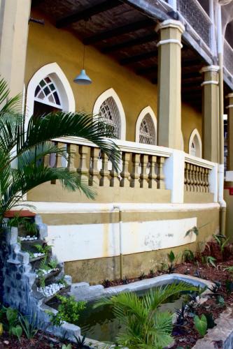 a house with a staircase and a pond in front of it at Royal Phoenix Inn in Panaji