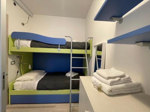 a room with two bunk beds and a counter with towels at Villa Antonietta 1, giardino privato, mare e pineta in Bibione