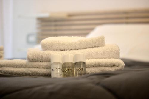 a pile of towels and moisturizers on a bed at Villa Antonietta 1, giardino privato, mare e pineta in Bibione