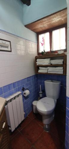 a blue tiled bathroom with a toilet and a sink at La Casona Del Almendro in San Bartolomé de Tirajana