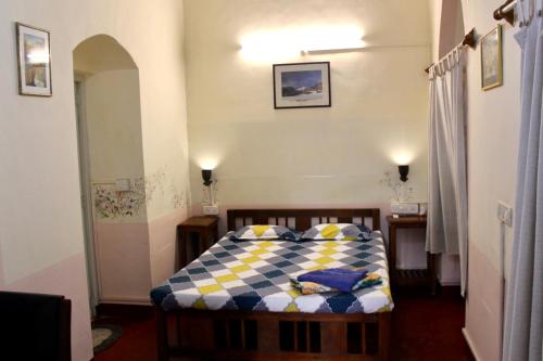 a bedroom with a bed with a checkered blanket at Royal Phoenix Inn in Panaji