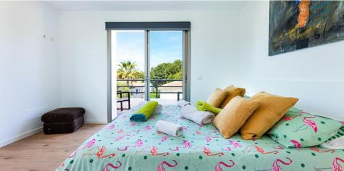 um quarto com uma cama com almofadas coloridas em Babamas 2 em Son Serra de Marina