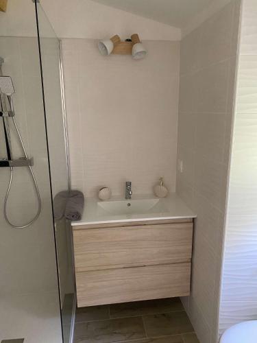 une salle de bain blanche avec un lavabo et une douche dans l'établissement Bel appartement au coeur du village de Sartene, à Sartène