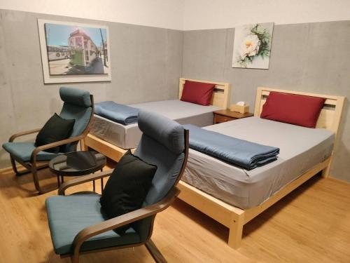 Cette chambre comprend 2 lits et des chaises. dans l'établissement 水源棧, à Fengyuan
