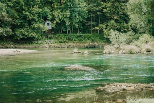 a river with a house in the middle of it at Apartments MoonRiver in Bihać