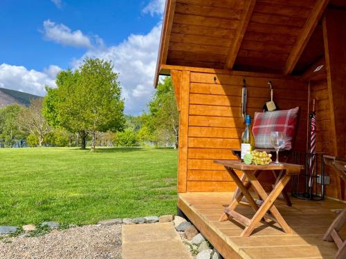 a picnic table with wine glasses and a flag on a cabin at Seal Cove Cabin - Luxury Glamping in Cairndow