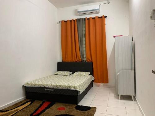 1 dormitorio con cama y cortina de color naranja en Homestay Sumayyah, en Kuantan