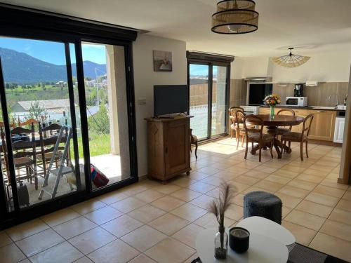 - un salon avec une table et une cuisine avec vue dans l'établissement Le nid Capcinois, à Formiguères