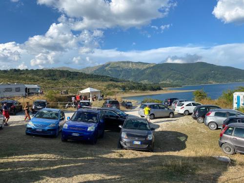 a group of cars parked in a parking lot next to a lake at Casa vacanze Lago di Campotosto in Campotosto