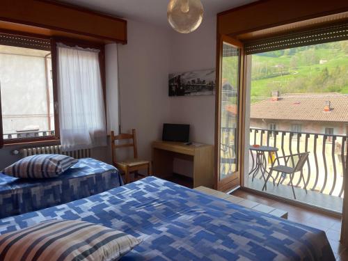 sypialnia z 2 łóżkami i balkonem z widokiem w obiekcie Hotel Americana w mieście Serina