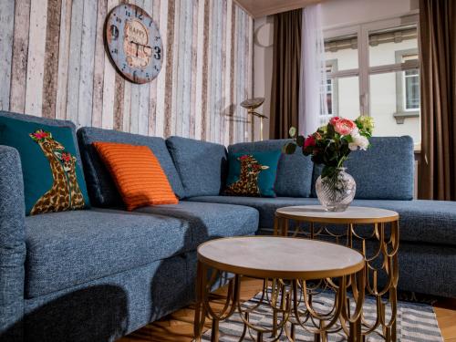 a living room with a blue couch and two tables at Haus Triflinger in Lindau