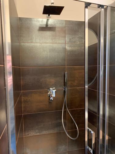 a bathroom with a shower with a glass door at Harmony Navigli Apartment in Milan