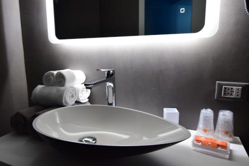 a white sink in a bathroom with a mirror at Hotel Fiume in Genoa