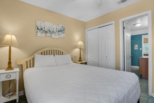 um quarto com uma grande cama branca e 2 candeeiros em Gulfview II 327 em Destin