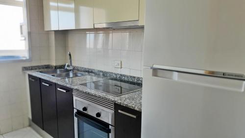 a kitchen with a sink and a stove at EUROPA I - Playa de Miramar in Miramar