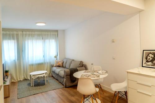 sala de estar con sofá y mesa en Preciosos apartamentos Riojaland en Lardero, en Lardero