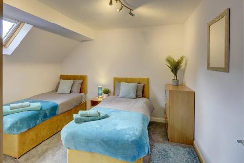 1 Schlafzimmer mit 2 Betten und einem Spiegel in der Unterkunft Park View - sleeps 7 great for 5 contractors in Warrington