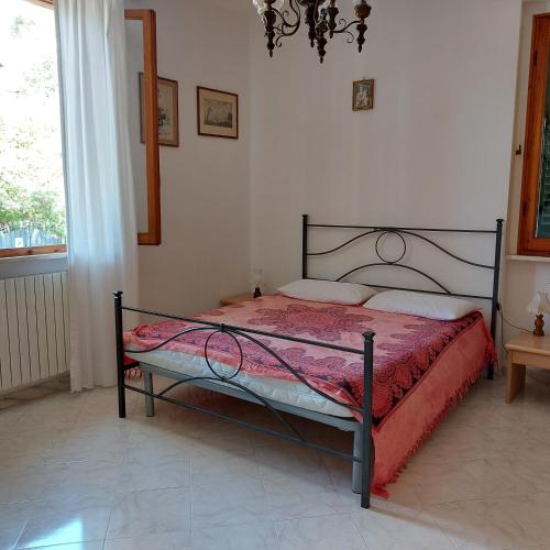 um quarto com uma cama com um edredão vermelho em Appartamento a due passi dal mare a Quercianella em Quercianella
