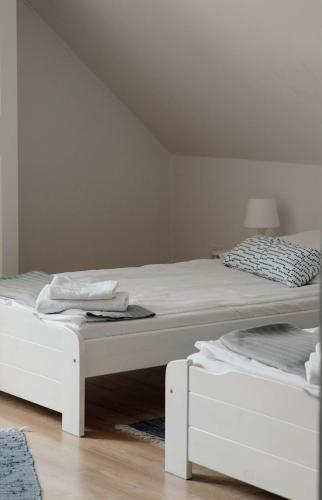 a bedroom with two white beds and a lamp at Gospodarstwo agroturystyczne Pod Wielkim Wozem in Jerutki