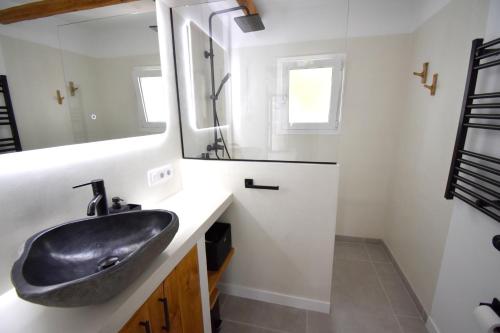 Un baño con un lavabo negro y un espejo. en Casa Markoli, en Jávea