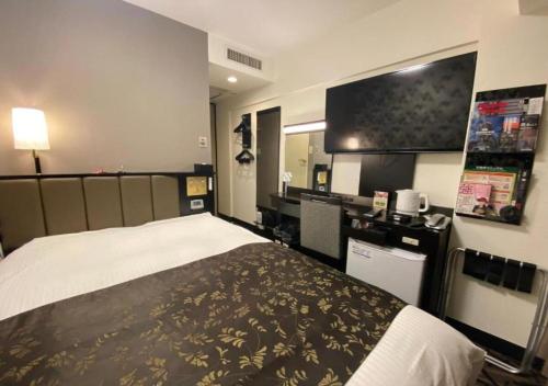 a hotel room with a bed and a flat screen tv at APA Hotel Hachioji Eki Kita in Hachioji