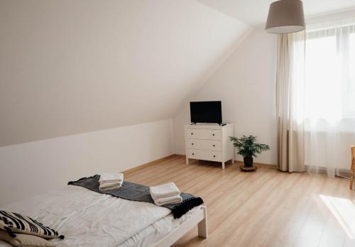 a white bedroom with a bed and a tv at Pod Wielkim Wozem in Jerutki