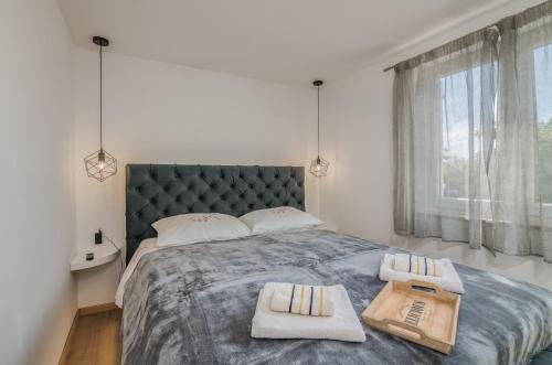 sypialnia z dużym łóżkiem z dwoma ręcznikami w obiekcie Apartmani Dino w mieście Vrh
