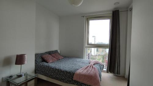 ein Schlafzimmer mit einem Bett und einem großen Fenster in der Unterkunft Riverview Amazing 2Bed 2Bath Apt wParking Sleeps 6 Comfortably in London