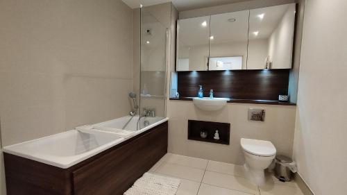 ein Badezimmer mit einer Badewanne, einem WC und einem Waschbecken in der Unterkunft Riverview Amazing 2Bed 2Bath Apt wParking Sleeps 6 Comfortably in London