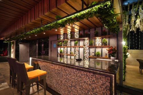 戈勒克布爾的住宿－Hotel Pradeep Star Inn，墙上有植物的餐厅里的酒吧