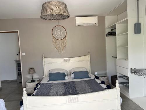 a bedroom with a large white bed with blue pillows at Villa Ananas La Réunion et piscine chauffée in Saint-Denis