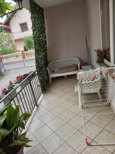 a patio with a bench and ivy on a house at Hostel Dragana in Podgorica