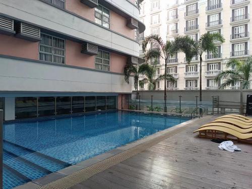 a swimming pool in front of a building at MS PASAY HOMESTAY STUDIO in 101 NEWPORT BLVD, FREE NETFLIX near AIRPORT NAIA T3, SAVOY & BELMONT in Manila
