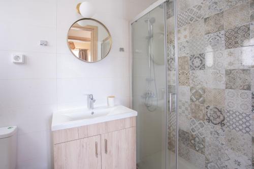 ein Bad mit einem Waschbecken und einer Dusche mit einem Spiegel in der Unterkunft Oikia Demetria Lefkas in Nydri