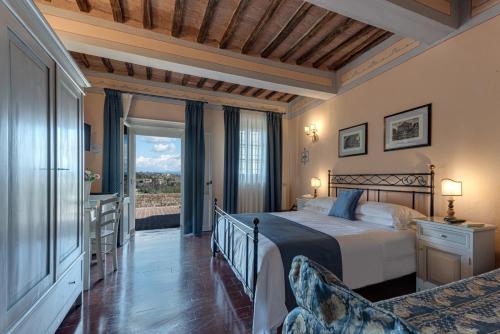 ein Schlafzimmer mit einem Bett und einem großen Fenster in der Unterkunft Hotel Palazzo di Valli in Siena