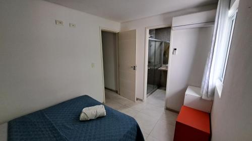 a bedroom with a blue bed and a bathroom at Casa de Luxo, 1 quadra do Mar em Porto de Galinhas in Porto De Galinhas