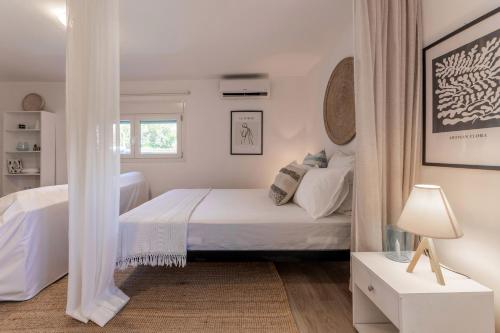 a white bedroom with a bed and a window at Countryside apartment in Foinikiá