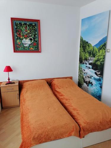 a bed in a room with a painting on the wall at Centrum One in Suwałki