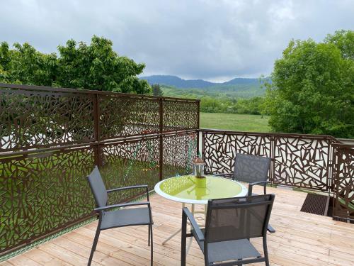 a patio with a table and chairs on a wooden deck at "Luci" proche du Zenith, Arténium Ceyrat, Auvergne, parking privé , in Beaumont