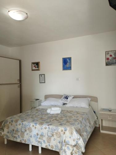 a bedroom with a bed with a comforter on it at Affitta Camere Zio Peppe in San Teodoro