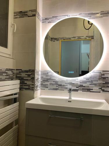 une salle de bain avec un lavabo et un miroir dans l'établissement Ideal Sejour - Le Mont-Dore, à Le Mont-Dore