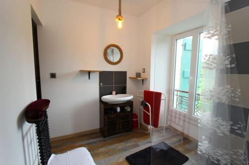 a bathroom with a sink and a mirror and a window at Charmant studio avec jardin à la campagne sur le chemin de Saint Jacques de Compostelle in Lauzerte